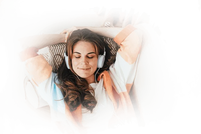 Woman relaxing with headphones on while listening to the Billionaire Brain Wave theta audio